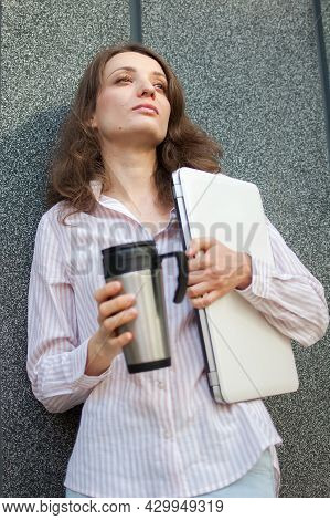 Female Portrait Of Young Woman With Silver Laptop And Cup Of Coffee Waiting For A Meeting Near Dark 