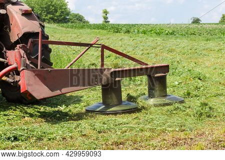Tractor Mounted Rotary Mower During Mowing Of Hay On A Hayfield At Summer Day, Fragment Close-up