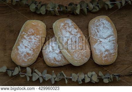 Three Homemade Sweet Cream Soft Buns And Sprinkled With Icing Sugar On Old Rustic Wooden Table. Bake