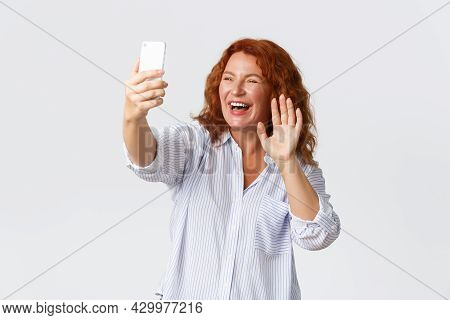 Technology And Communcation Concept. Friendly And Outgoing Smiling, Attractive Middle-aged Redhead W