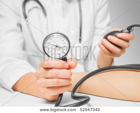 Doctor measures blood pressure by sphygmomanometer