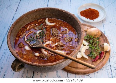 Beef stew in a pot and its main ingredients