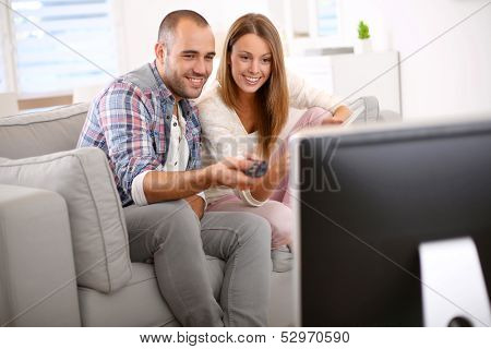 Young couple at home looking for tv progam
