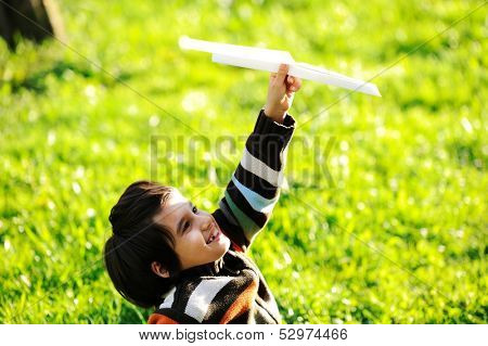 Happy kid enjoying sunny late summer and autumn day in nature on green grass