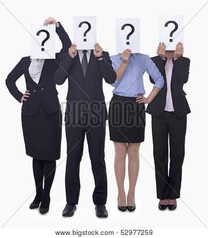 Four business people holding up paper with question mark