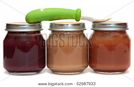 Three jars of baby food and spoon