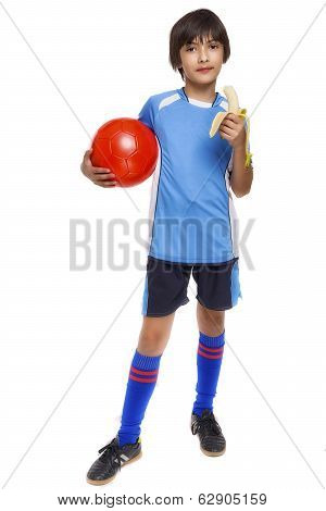 Young Soccer Player Eating Banana As Halftime Snack