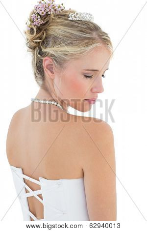 Rear view of shy bride in off shoulder dress over white background