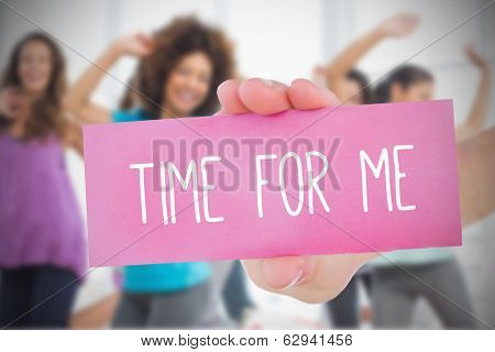 Woman holding pink card saying time for me against class in gym