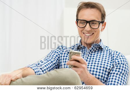 Portrait Of Young Man Listening To Music With IPod