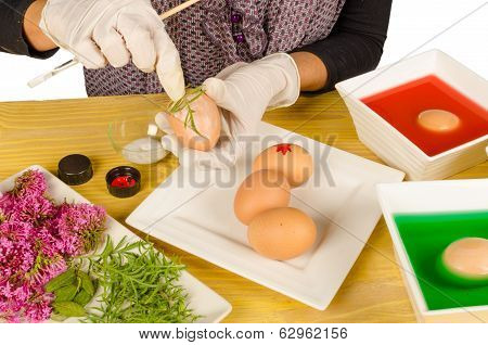 Hands decorating Easter eggs