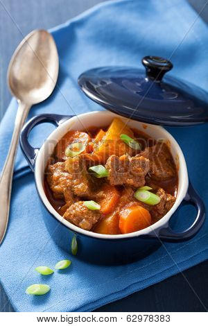 beef stew with potato and carrot in blue pot