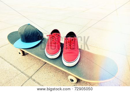 skateboard and sneakers at skatepark
