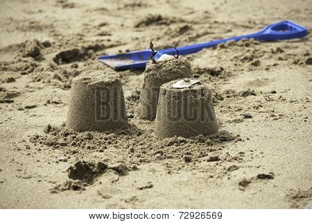 Three Simple Sandcastles with Blue Spade