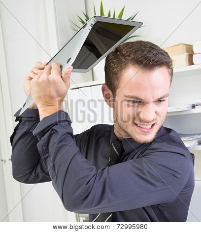 Close up of furious businessman throwing his laptop away