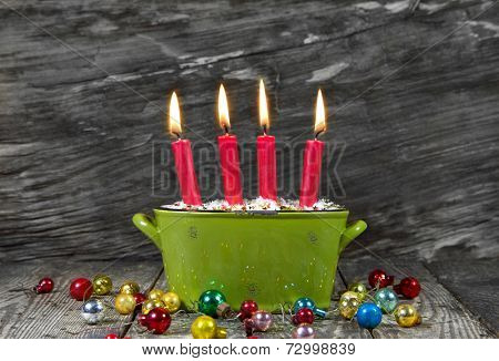 Four red christmas candles - traditonel in green and red - decoration advent on a old wooden background for a greeting card 