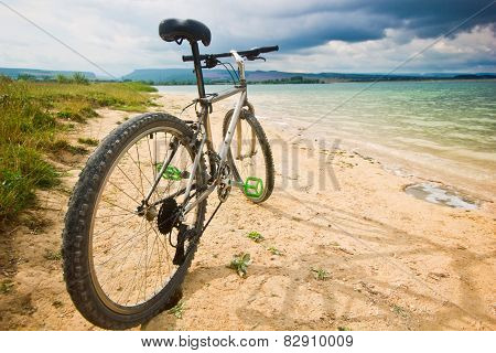 bicycle on a bank of blue lake