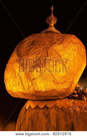 KYAIKTIYO, MYANMAR - JANUARY 4, 2014: People worshipping at Golden Rock - Kyaiktiyo Pagoda - famous Myanmar landmark, Buddhist pilgrimage site and tourist attraction, Myanmar