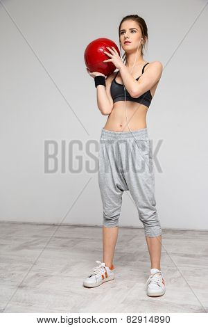 Beautiful sports woman working out with a medicine ball