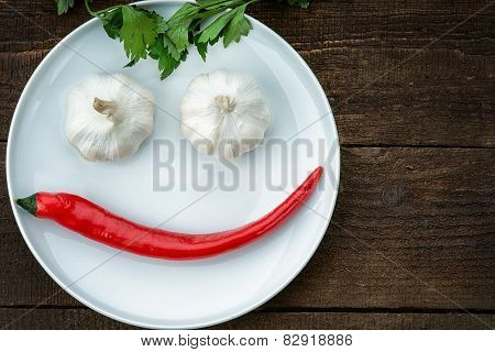 Smiley face made from pepper, garlic and parsley
