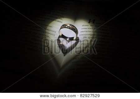 Golden ring with heartshadows in the middle of the book