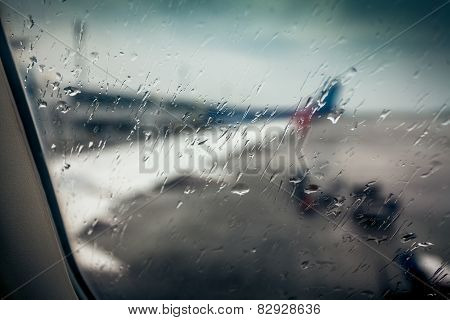 Airplane Wing Through Passenger Window With Rain Drops