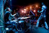 Band performs on stage, rock music concert. Warning - authentic shooting with high iso in challengin