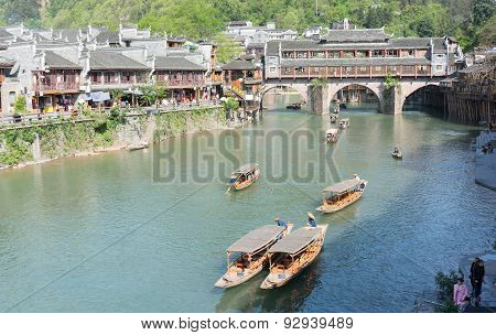 FENGHUANG - April 13:Wooden boats with tourists at Fenghuang ancient town on April 13 2015 in FenghuangChina.Fenghuang ancient town was added to UNESCO World Heritage Tentative List.