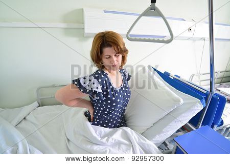 Female Patient With Back Pain On  Bed In Hospital Ward