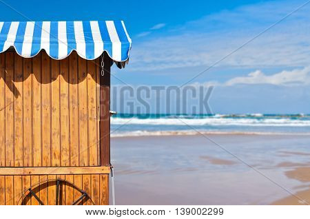 Wooden stall with awning over sea and sky background