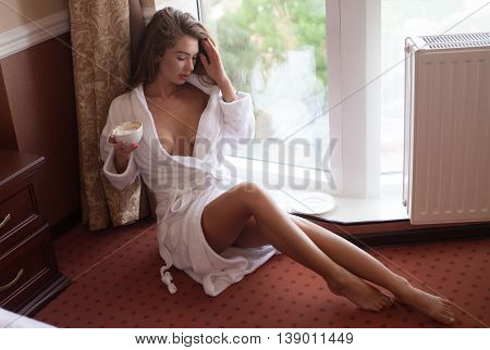 Young sexy woman . Young woman enjoying her morning coffee.