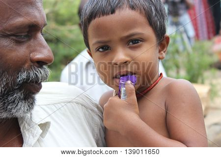 indian village boy eating chocalte for his hunger