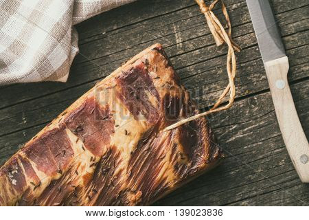 Fresh smooked bacon on old wooden table.