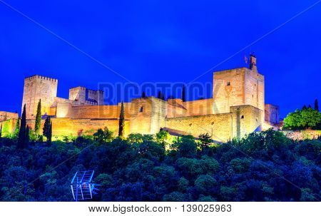 Panoramic view of Alhambra palace on the hill illuminated at night in Granada - Andalusia Spain