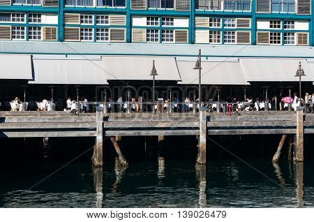 Finger wharf restaurant in Woolloomooloo bay with unrecognisable people in the distance. Sydney Australia