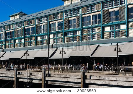 Finger wharf restaurant in Woolloomooloo bay with unrecognisable people in the distance. Sydney Australia