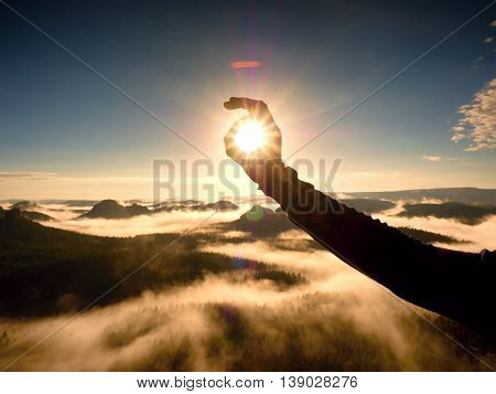 Man Hand Touch Sun. Misty Daybreak In A Beautiful Hills.