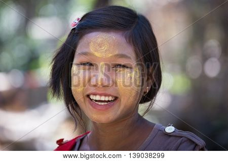 MRAUK-U MYANMAR - JANUARY 27 2016: Unidentified young Myanmar girl with thanaka on her smile face is happiness. Thanaka is a yellowish-white cosmetic paste made from ground bark.