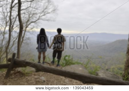 blurred image of couple looking view at mountain
