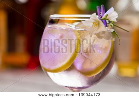 Lemon slices in transparent drink. Cocktail in decoreted wineglass. Expensive beverage made at bar. How to make tom collins.