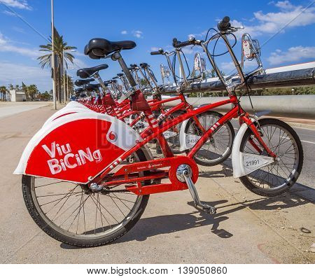 BARCELONA SPAIN - JULY 13 2016: Bicycles on a street of Barcelona. Public Service Vehicles bicycles Vodafone Bicing. Bicing is the name of a bicycle sharing system in Barcelona inaugurated on March 22 2007.