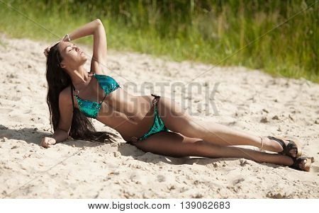 attractive sexy asian woman in bikini, outdoor shot in sand, summer day. Beauty at the beach sand around. Fashion shot of beautiful woman on the beach.