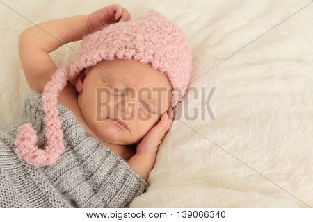 Newborn baby girl asleep on a blanket.