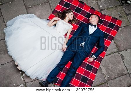Wedding Couple Lying On Blankets. Photo From Quad Copter Drone View