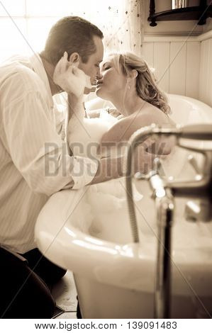Couple playful bubble bath kiss while on holiday.