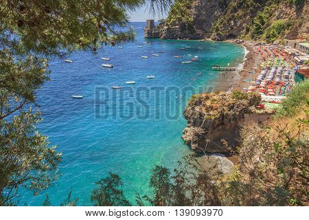Summertime sescape: Amalfi Coast (Costiera Amalfitana).The best beaches in Italy:Positano seaside (Campania).Beach set in the cliff: the background a watchtower.