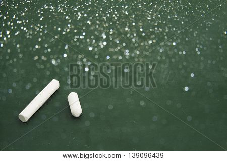 Blackboard and chalks with glister light background.