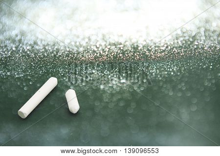 Blackboard and chalks with glister light background.