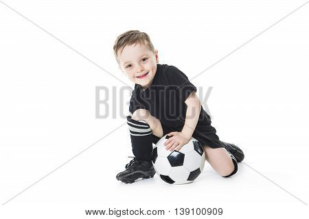 A Cute boy is holding a football ball isolated on a white background. Soccer