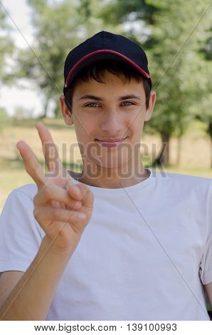 Close up portrait of a cute teenager in a baseball cap with blue eyes. Outdoors.